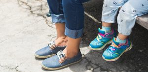 A shot of the feet of a mother and child sitting on a park bench.